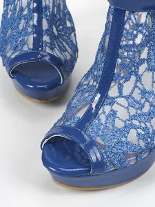 Gros plan de sandales à plateforme bleues avec dentelle et bout ouvert en cuir verni