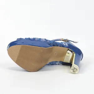 Vue de dessous des sandales à plateforme en dentelle bleue avec talon bloc doré et semelle
