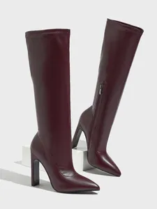 Elegant burgundy faux leather knee-high boots with pointed toe and high chunky heel.