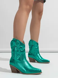 Detailed view of green metallic western boots with vintage embroidery and chunky heels