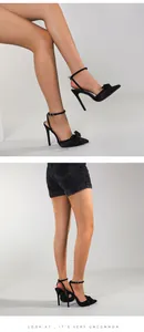 Close-up detail of elegant black stiletto heels featuring a bow accent and ankle strap