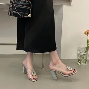 Elegant PVC transparent high-heeled mules with sparkling rhinestone buckle and chunky heel.
