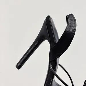 Close-up of the elegant black silk stiletto heel and ankle strap construction