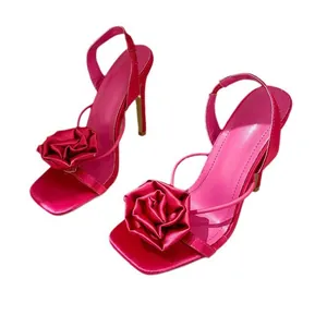 Fuchsia pink silk sandals featuring a square toe and a large decorative rose on the front strap