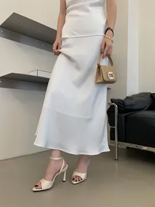 Detalle de sandalias de tacón de aguja beige elegantes con punta cuadrada y tira al tobillo.