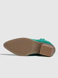 Close-up of the brown non-slip sole and chunky heel of a green metallic western boot