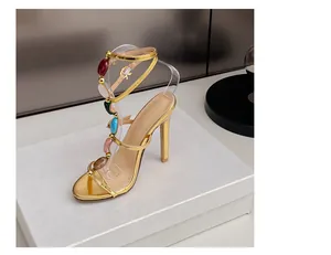 Detailansicht goldene High-Heel-Sandalen mit buntem Edelstein-T-Riemen