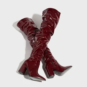 Close-up of wine red patent leather over-the-knee boots with natural slouch design