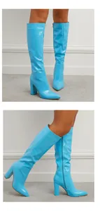 Side view of light blue knee-high boots with crocodile texture and chunky high heels