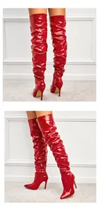 Détails latéraux et arrière de bottes cuissardes rouges en cuir verni à talons aiguilles