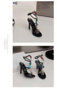 Detail der sexy schwarzen T-Strap-Sandalen mit hohen Absätzen und bunten Edelsteinperlen