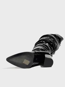Close-up detail of the anti-slip sole and shiny black patent leather crinkle texture.