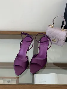 Elegantes sandalias de satén morado con tira al tobillo y tacón alto en escena real