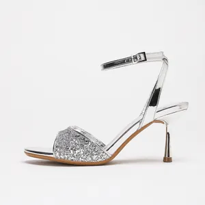 Elegant silver glitter ankle strap sandals with stiletto heels for wedding parties.