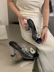 Elegant black chunky heel sandals with clear PVC strap and shiny rhinestone buckle detail