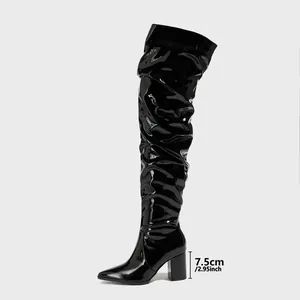 Close-up detail view of black patent leather thigh-high boots with 7.5cm chunky heel