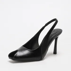 Elegantes zapatos de tacón de aguja destalonados en piel encerada negra con punta abierta.