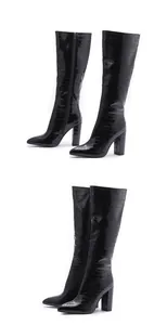 Detail view of black croc-embossed knee-high boots with pointed toe and block heel.