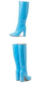 Macro view of blue crocodile embossed knee-high boots with pointed toe and block heel