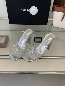 Close-up of silver high heel sandals with transparent PVC strap and rhinestone buckle