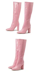Close-up of pink crocodile pattern tall boots with pointed toe and block heel.