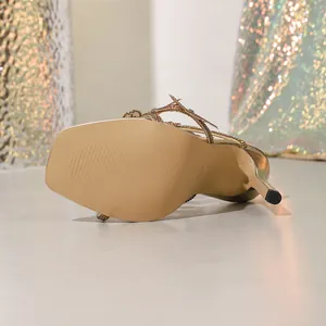 Detailed view of the gold square-toe stiletto sandal with elegant rhinestone flower decor