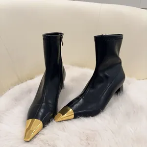 Elegant black leather ankle boots with metallic gold pointed toe and slim high heels