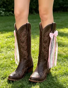 Pink ribbon and pearl strand charms for cowboy boots shown on dark brown leather