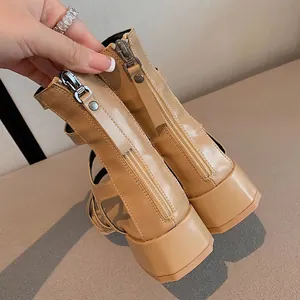 Gros plan sur la fermeture éclair métallique à l'arrière de ces sandales beiges à talons épais