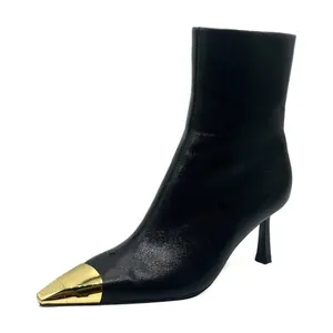 Elegant black pointed toe ankle boots featuring a striking gold metallic toe cap and stiletto heel.