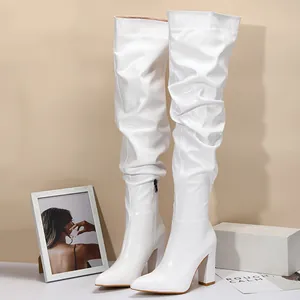 Stylish white over-the-knee slouchy boots with chunky block heels and pointed toe design.