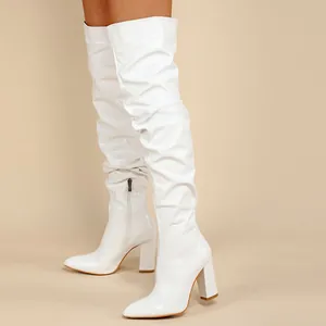 Vue détaillée de bottes hautes blanches plissées avec talons blocs et bouts pointus