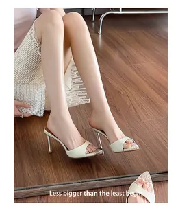 Detailed view of elegant off-white pointed mules with rhinestone embellishments