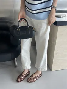 Brown woven hollow-out flat sandals showcased in a French-style chic casual outfit