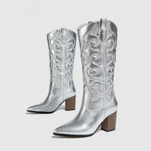 Close-up of metallic silver western cowboy boots with intricate embroidery and block heel
