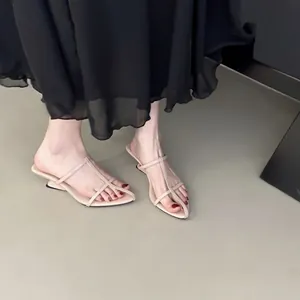 Nahaufnahme von eleganten beigen Keilsandaletten mit minimalistischen dünnen Riemchen