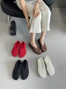 Detailed view of hollow woven flat sandals in red, black, white, and brown colors