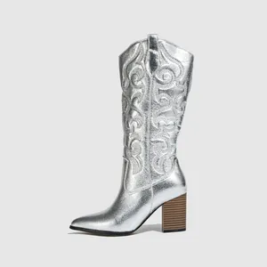 Elegant metallic silver cowboy boot with embroidered details and mid-high block heel