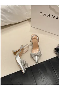 Detail der silbernen spitzen Pumps mit funkelnder Strassschleife und Slingback-Riemen