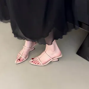 Nahaufnahme von eleganten nudefarbenen Riemchensandalen mit skulpturalem Keilabsatz