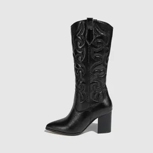 Detailed view of black embroidered cowboy boots with pointed toe and block heel design