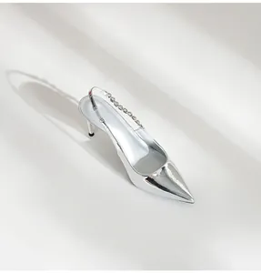 Detailed view of silver pointed-toe slingback heels with elegant rhinestone strap
