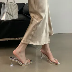 Detailed macro view of transparent silver high-heeled sandals with rhinestones and pointed toe