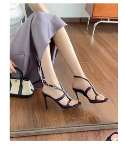 Close-up view of purple rhinestone chain high heel sandals on a model for detail.