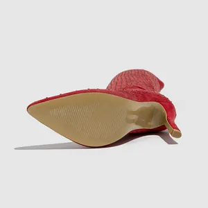 Vue détaillée de la semelle antidérapante et du daim rouge sur les bottes à talons
