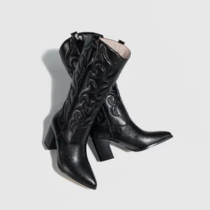 Detailed view of black embroidered Western cowboy boots featuring pointed toe and chunky heel