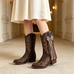 Detailed macro view of decorative ribbon bows and pearl charms on brown western boots.