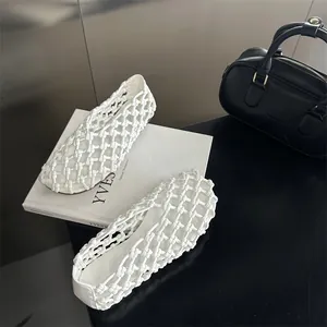 Close-up detail of white hollow woven flat shoes featuring an elegant French style design