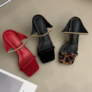 Détail de trois sandales à talons hauts à bout carré avec accents en métal doré
