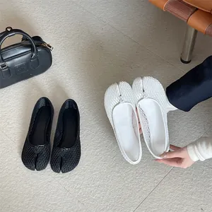Detailansicht modischer Tabi-Netz-Ballerinas mit geteilter Zehenpartie in Schwarz und Weiß.